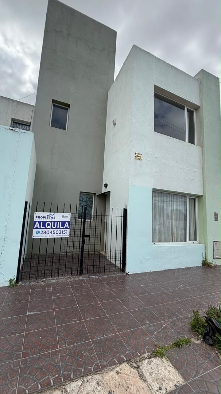 Frente del dúplex de Castelli 97 con reja y el cartel de alquiler de Propietas Inmobiliaria