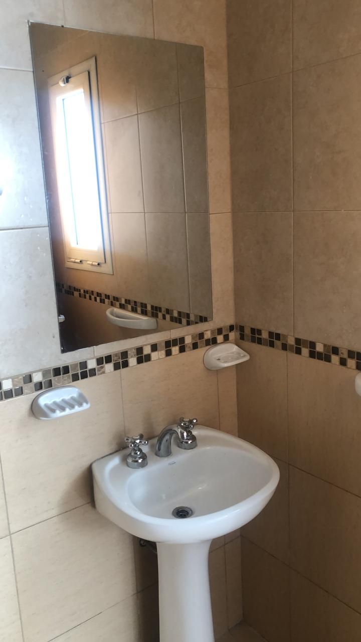 Lavatorio con espejo y ventana en el baño